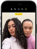 iPhone 18 Pro, noir, face avant, affichant deux modèles qui posent pour la caméra, mettant en avant la caméra avant Center Stage